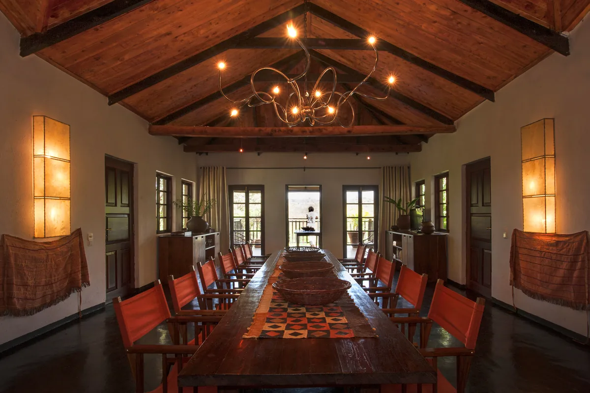 Long dining table under the timber roof of the Garden House