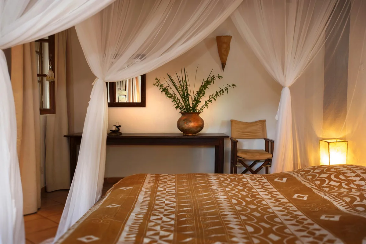 Jacaranda Suite bedroom with canopy bed and mosquito net